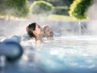 Couple enjoys time out in the outdoor pool in Southeast Styria