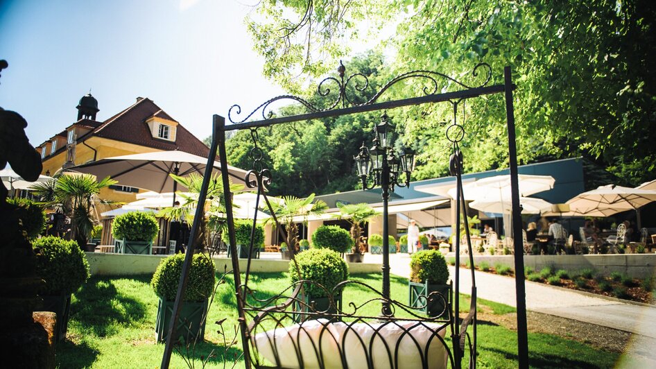 aiola im Schloss I Essen & Trinken in Graz | © aiola - Joel Kernasenko Gemütlicher Gartenbereich mit Hängeschaukel und sonnigem Ambiente. | © aiola - Joel Kernasenko
