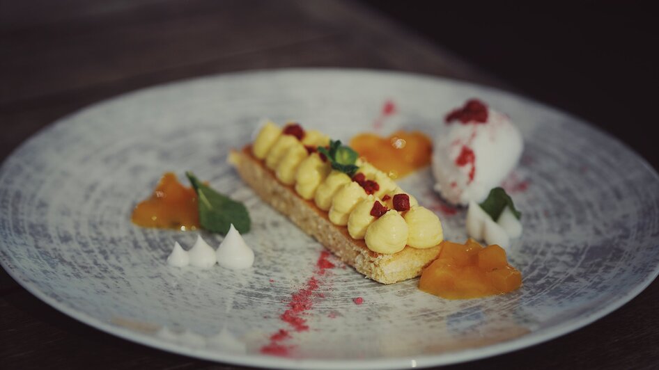 Köstliches Dessert mit Creme, Fruchtgelees und Eis auf einem Teller. | © aiola