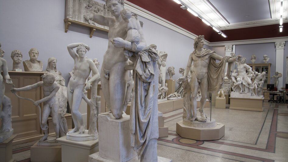 Raum mit weißen Skulpturen, die antike Figuren darstellen.