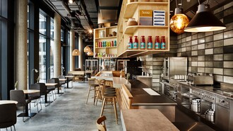 Modernes Restaurant mit Barbereich und offener Küche.
