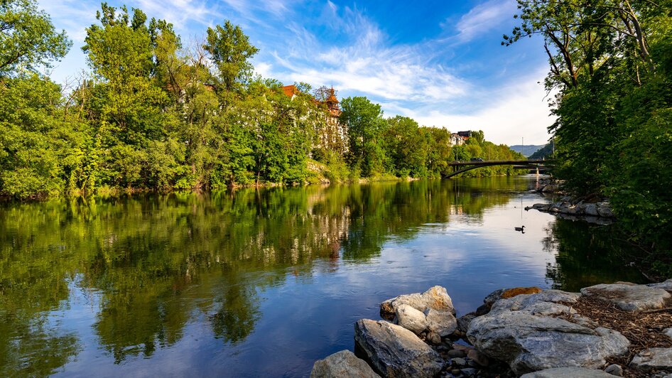 Ruhe der Augartenbucht in Graz | © Graz Tourismus - Harry Schiffer Spiegelung der Natur an der Augartenbucht in Graz mit klarem Wasser und grünen Bäumen. | © Graz Tourismus - Harry Schiffer