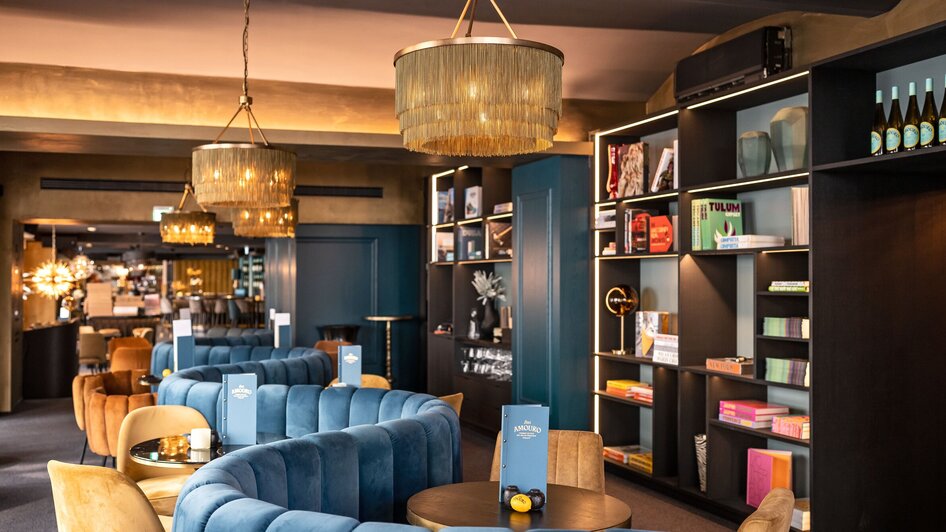 Gemütliche Bar mit moderner Einrichtung in Graz, Bücherregale und stylische Lampen.