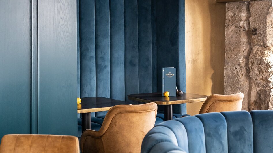 Gemütliche Sitzgelegenheiten in der Bar Amouro mit blauem Design.