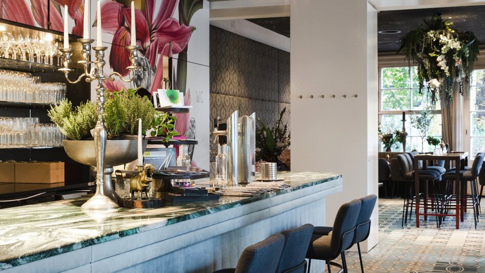 Elegantes Café mit stilvollem Interieur und buntem Fliesenboden.
