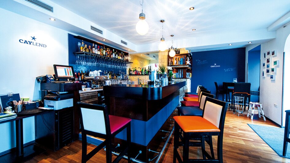 Gemütliche Bar mit einer Vielzahl an Getränken und Sitzmöglichkeiten.
