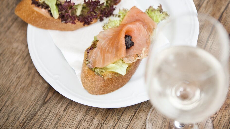 Zwei Brötchen mit Lachs und Shrimps auf einem Teller.