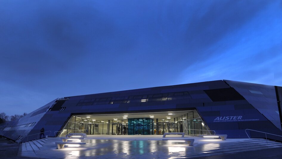 Futuristisches Schwimmbadgebäude Auster in Graz bei Dämmerung.