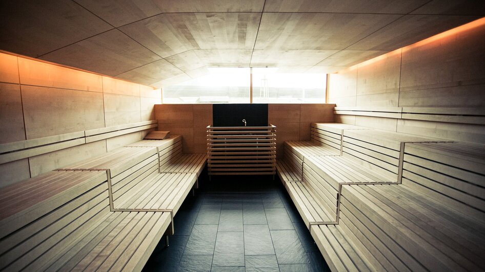 Stilvolle Sauna mit Holzbänken und indirekter Beleuchtung.