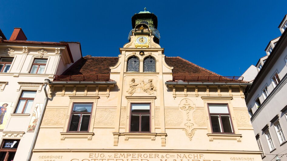 Fassade des Grazer Glockenspiels mit Uhr und Verzierungen.