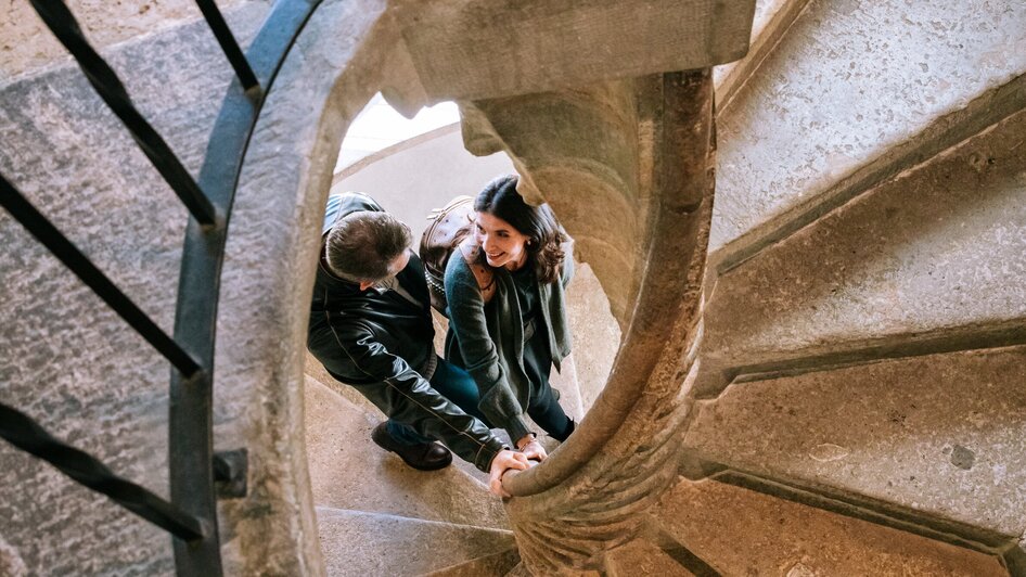 Zwei Personen steigen die berühmte Doppelwendeltreppe hinauf.