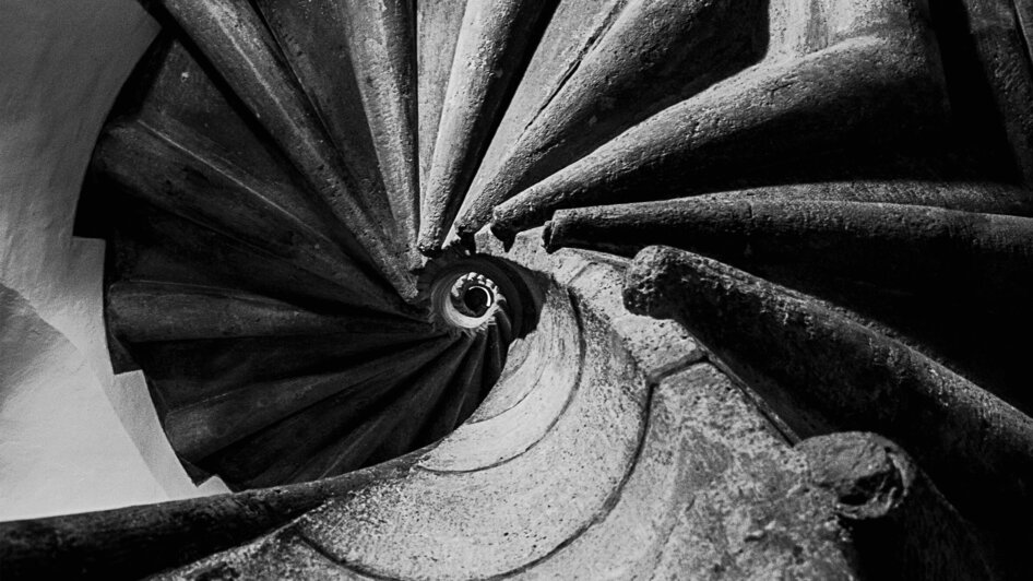 Ansicht der Doppelwendeltreppe in Schwarzweiß, die spiralförmig nach unten führt.
