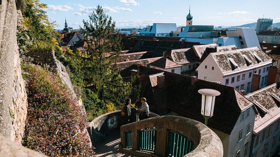 Blick auf Graz vom Schlossbergsteig mit Stadthäusern und schöner Dachlandschaft.