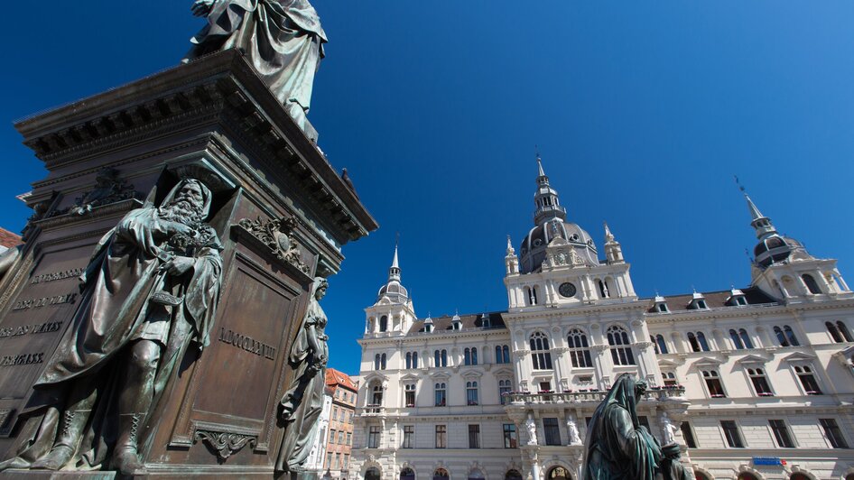 Blick auf das Rathaus am Hauptplatz in Graz mit Statuen im Vordergrund. | © Graz Tourismus - Harry Schiffer