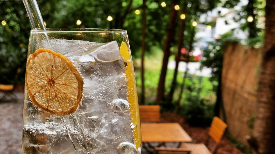 Ein erfrischendes Getränk mit Eis und Zitrone in einem Garten.