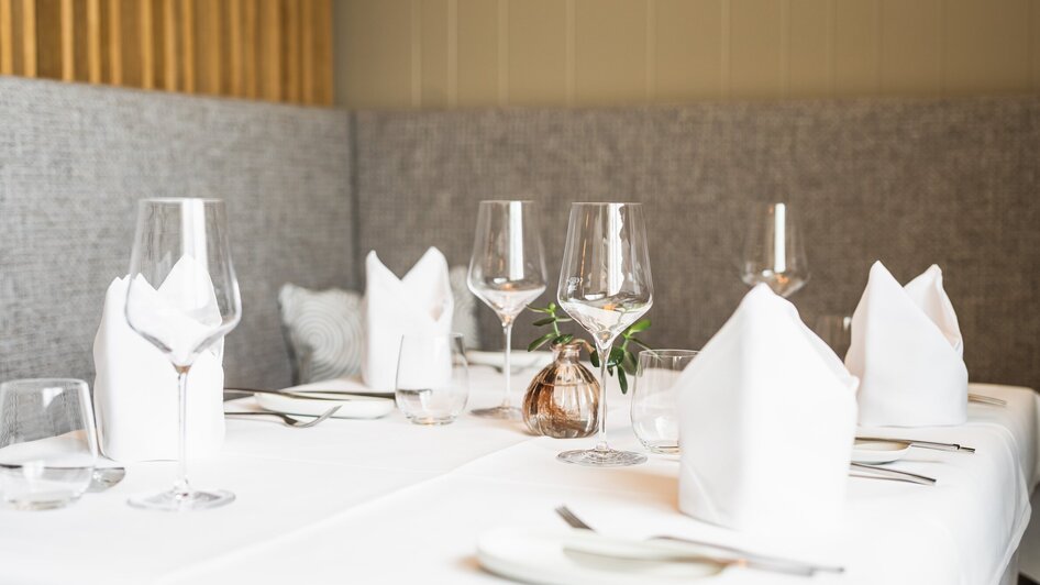 Elegante Tischdekoration mit Gläsern und Servietten im Gasthaus.