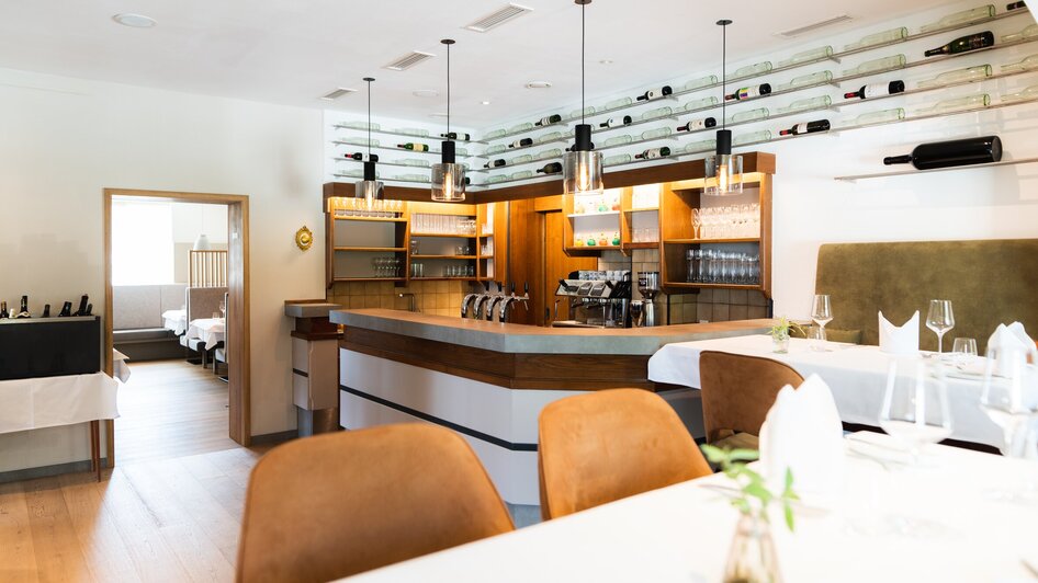 Modern eingerichtetes Restaurant mit Bar und Sitzplätzen.