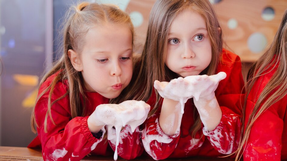Mädchen machen Seifenblasen - in der Ausstellung "Seifenblasen Träume" im Kindermuseum FRida & freD | © FRida & freD - Edi Haberl