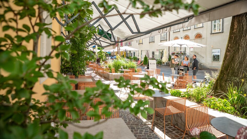Gemütliche Außenterrasse des KLYO mit Pflanzen und Gästen in Graz. | © mpview