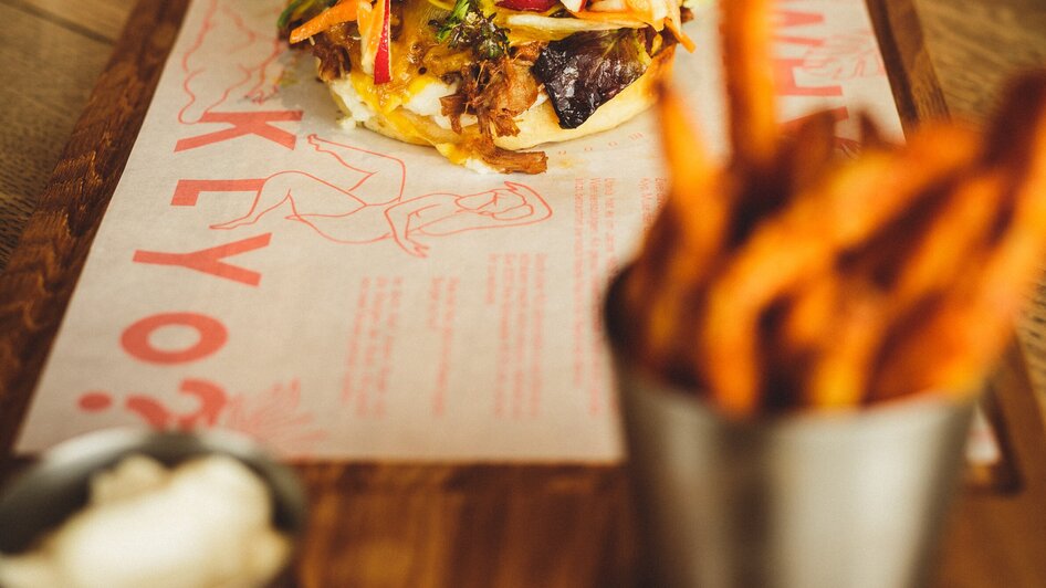 Ein köstlicher Burger mit Beilagen in einem Restaurant. | © Aaron Jiang