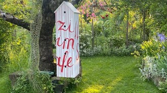 Ein farbenfrohes Schild im Garten mit dem Text 'zi um je'. | © kunstGarten