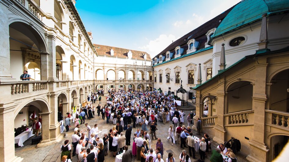 Vielzahl von Menschen im Landhaushof in Graz versammelt - bei der Langen Tafel der GenussHauptstadt. | © Graz Tourismus - Harry Schiffer