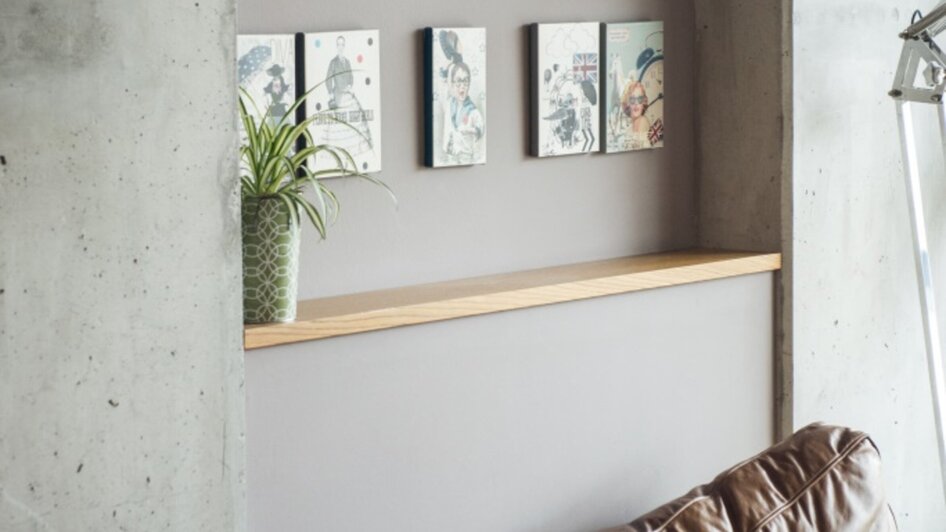Ein modernes Café mit einer Ledercouch und Kunst an der Wand.