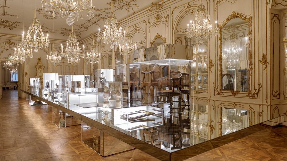 Ein prächtiger Ausstellungsraum mit Vitrinen und kronleuchtern. | © UMJ - N. Lackner