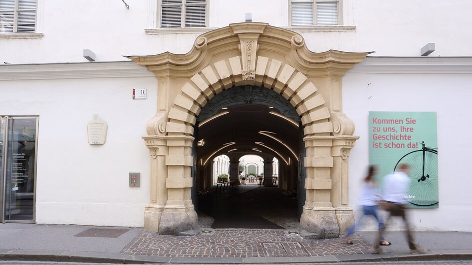Historischer Torbogen mit Werbung für ein Museum in Graz. | © UMJ - J. Kucek