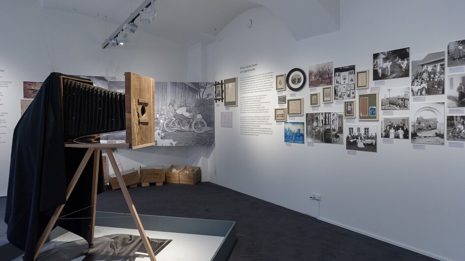 Ausstellung mit historischer Kamera und Fotografien an der Wand. | © UMJ - N. Lackner