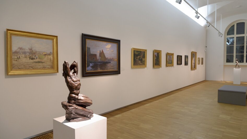 Innenansicht der Neuen Galerie mit Skulptur und Bildern.