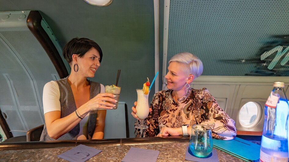 Zwei Frauen stoßen in der NOVA-AIR Bar in Graz an.