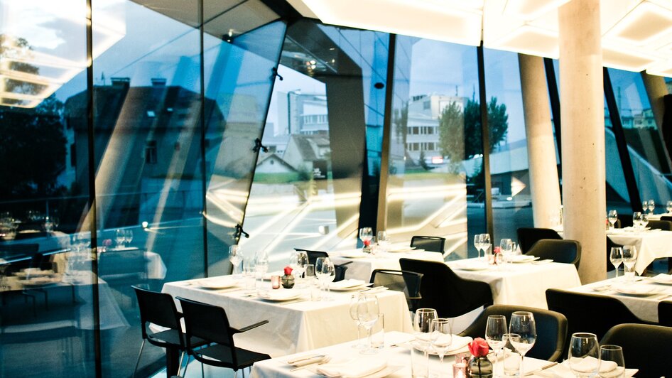 Elegantes Restaurant in Graz mit modernen Möbeln und Panoramaausblick.