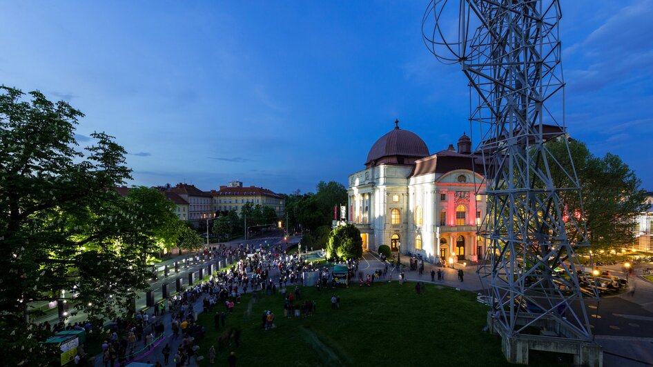 Menschenmenge vor der beleuchteten Oper Graz bei Dämmerung. | © Graz Tourismus - Harry Schiffer