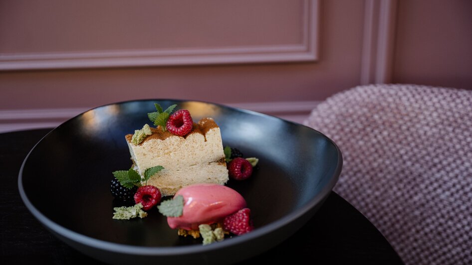 Ein kunstvoll angerichtetes Dessert mit Torte und Sorbet.