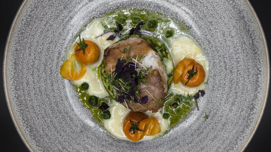 Ansicht eines kunstvoll angerichteten Tellers mit Fleisch und Gemüse.