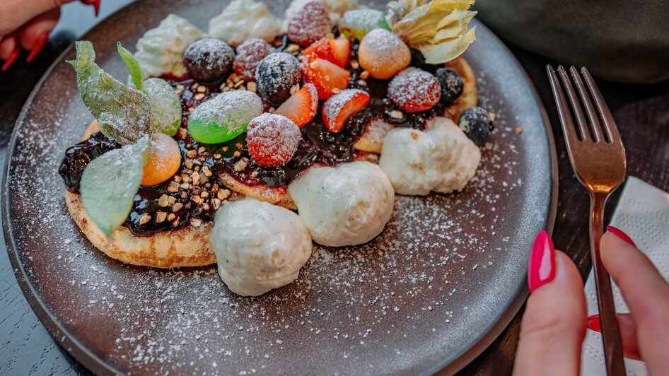 Ein köstliches Dessert mit Früchten und Sahne im Operncafé in Graz.
