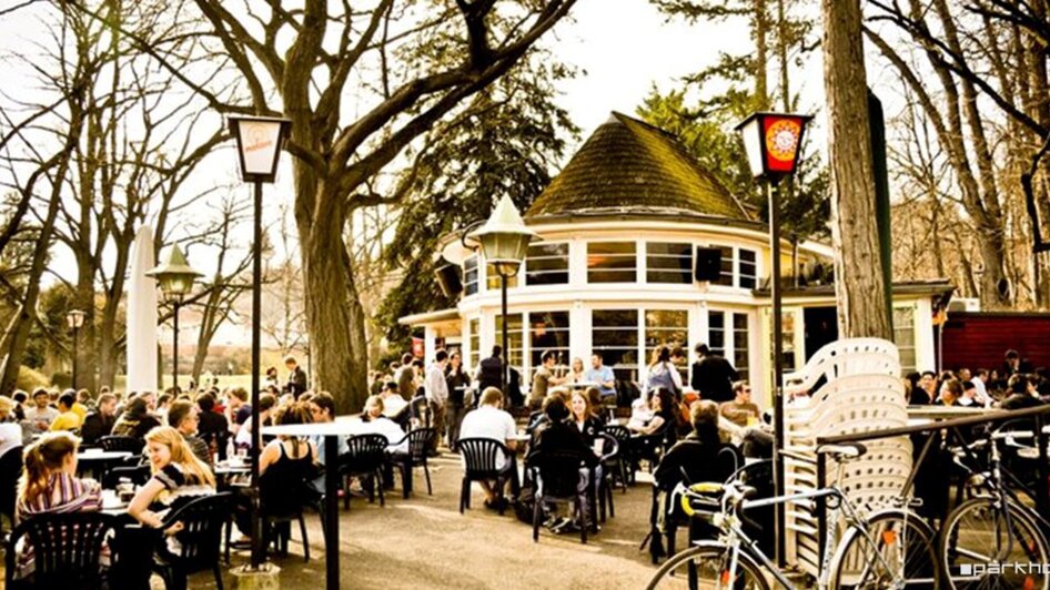 Gemütliche Atmosphäre im Parkhouse mit vielen Gästen draußen.