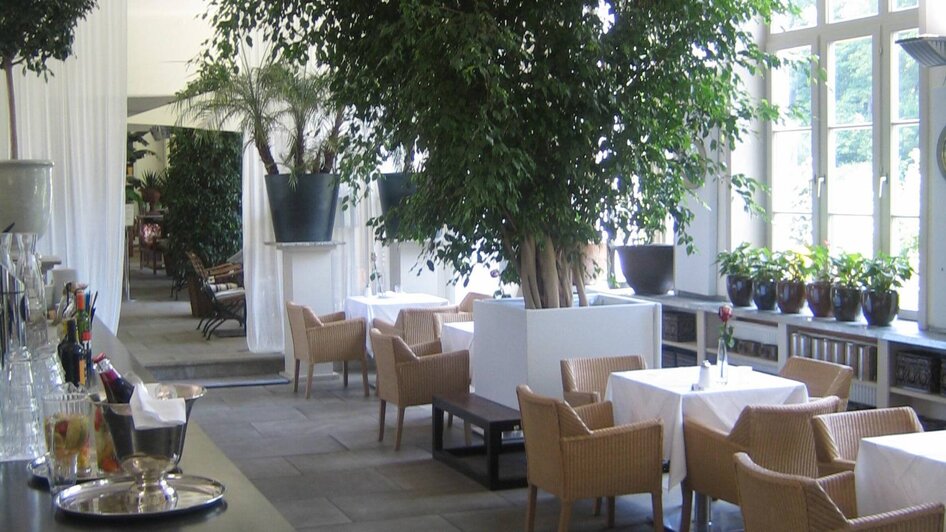 Helles Restaurant mit Pflanzen, eleganten Tischen und Bar. | © Purberg