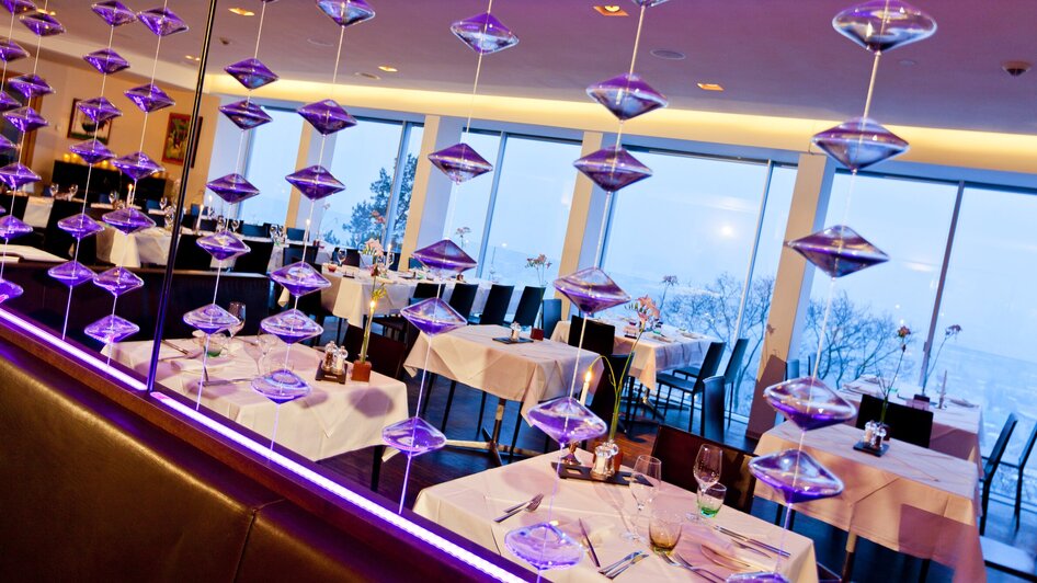 Moderne Restaurantansicht mit Tischdekoration und Glasobjekten. | © Schlossberg - Werner Krug