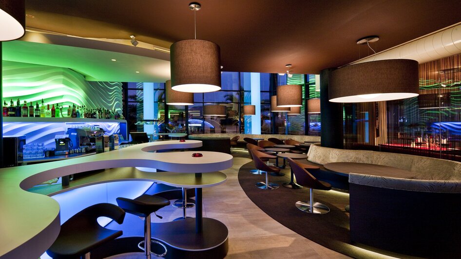 Moderne Bar mit stilvollem Lichtdesign und Sitzbereichen.