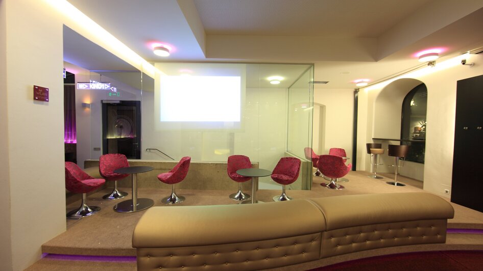 Moderne Lounge mit roten Stühlen und gemütlicher Atmosphäre.
