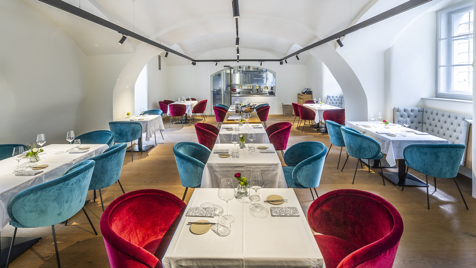 Elegantes Restaurant mit bunten Stühlen und gedeckten Tischen.