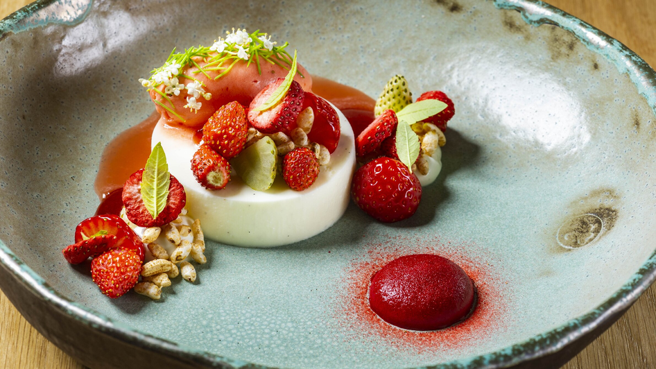 Köstliches Dessert mit Panna Cotta, Erdbeeren und Fruchtsoße.