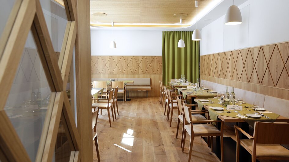 Moderne Restaurantansicht mit Holzinterieur und grünen Akzenten.