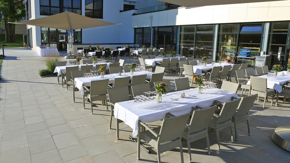 Terrasse des Steiermarkhofs mit gedeckten Tischreihen für ein Event.