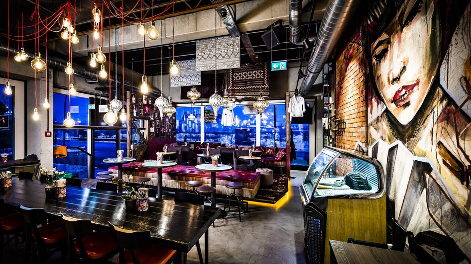 Gemütliches Restaurant mit urbanem Design und Wandbildern.