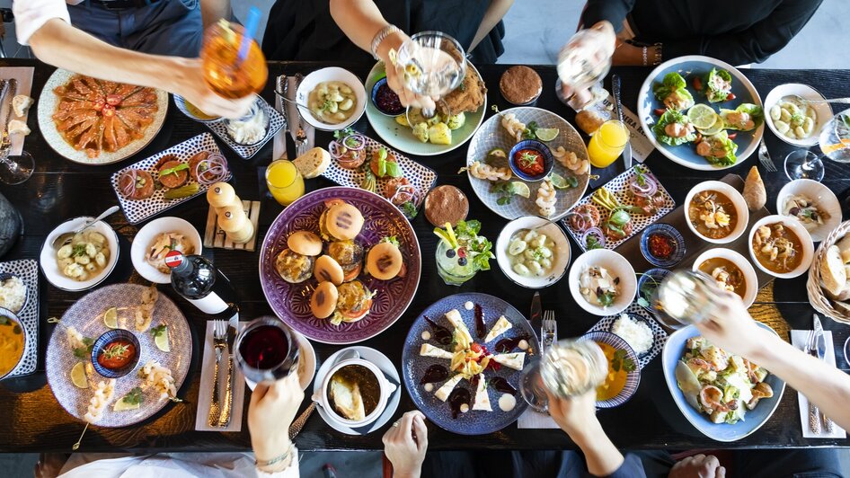 Lebhafte Tafel mit vielfältigen Speisen und Getränken.