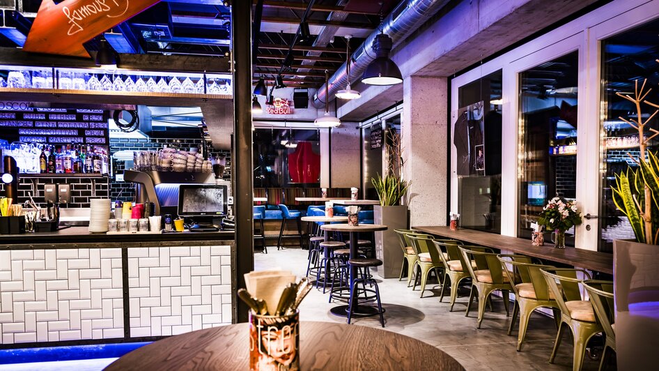 Moderne Restaurantinneneinrichtung mit Bar und Sitzplätzen.