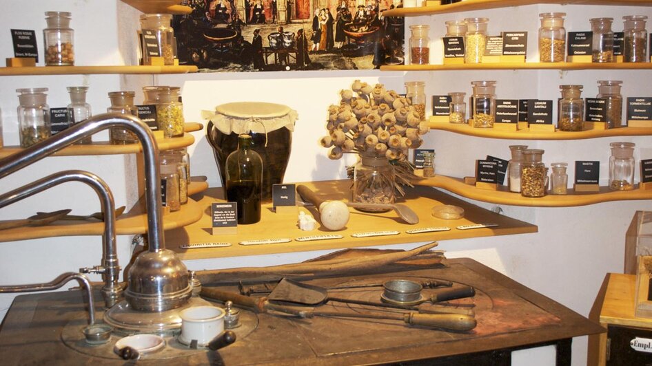 Eine historische Apotheke mit Gläsern, Kräutern und Gerätschaften.